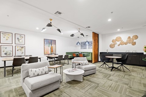 A room with a carpeted floor and a variety of furniture including a couch, chairs, and a coffee table.