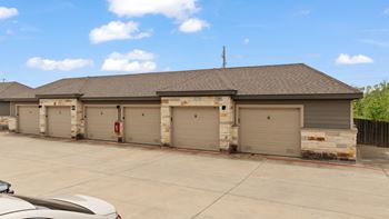 A building with a grey roof and a white car in front.