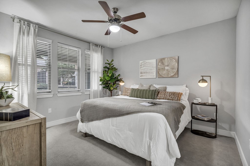 a bedroom with a bed and a ceiling fan