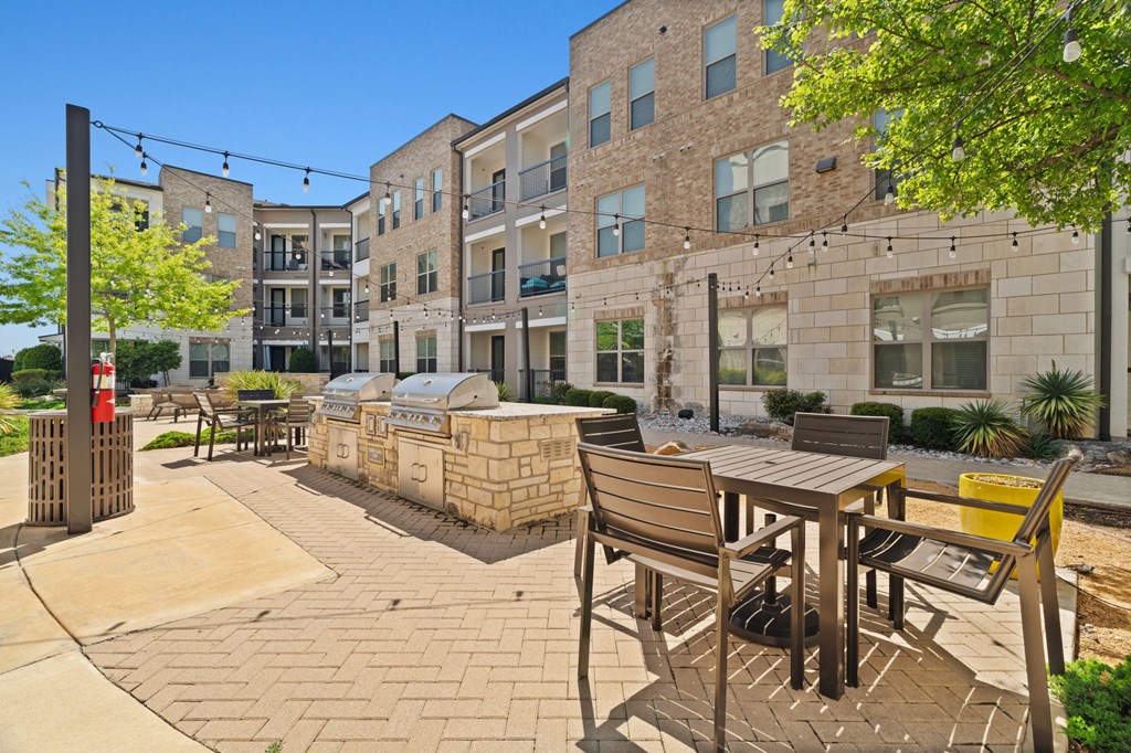 A sunny day at a courtyard with a table and chairs.