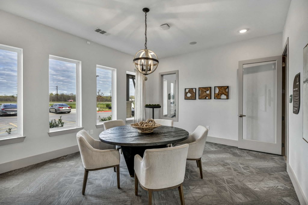 a dining room with white walls and a table and chairs