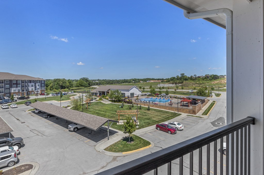 a balcony with a view of a park and a pool