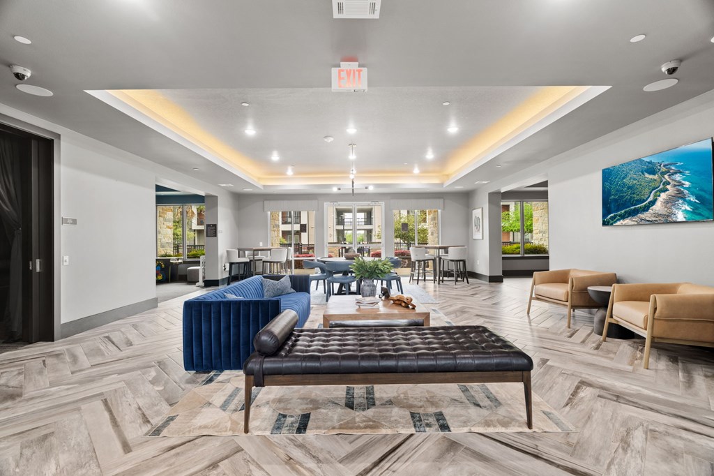 A spacious waiting area with a variety of seating options and a large painting on the wall.