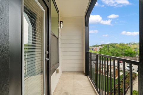 A balcony with a black railing and a view of the sky.