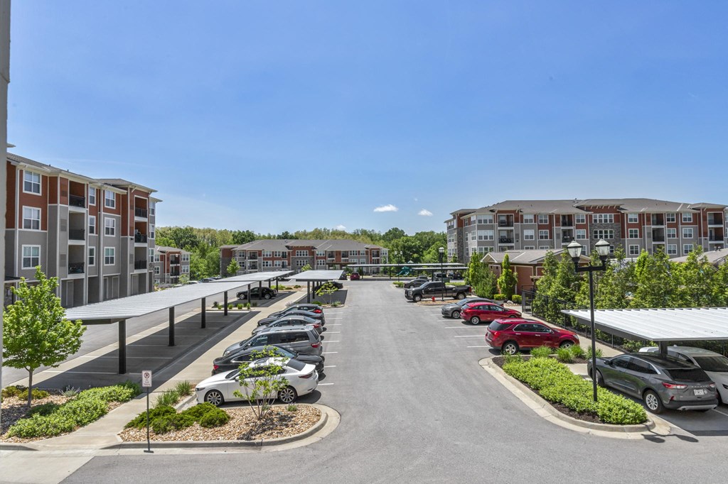an empty parking lot with apartments in the background