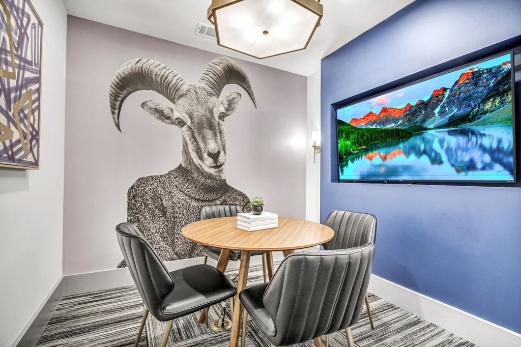 a dining room with a table and a goat mural on the wall