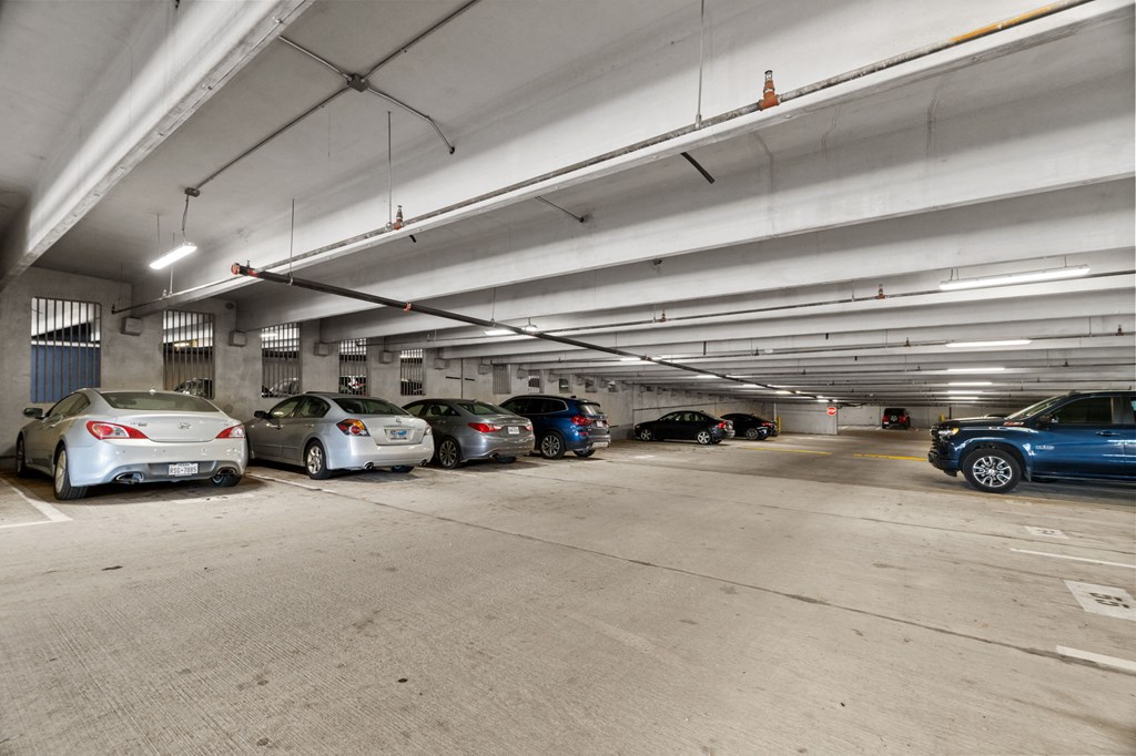 A parking garage with several cars parked in it.