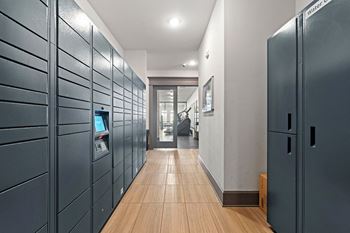 a long hallway with blue lockers and wood floors