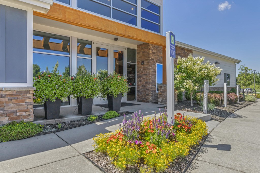 the front of a building with flowers in front of it