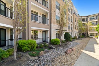Apartment complex with a gravel pathway in front.