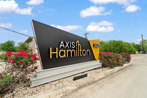 A sign for Axis in Hamilton is displayed in front of a building.