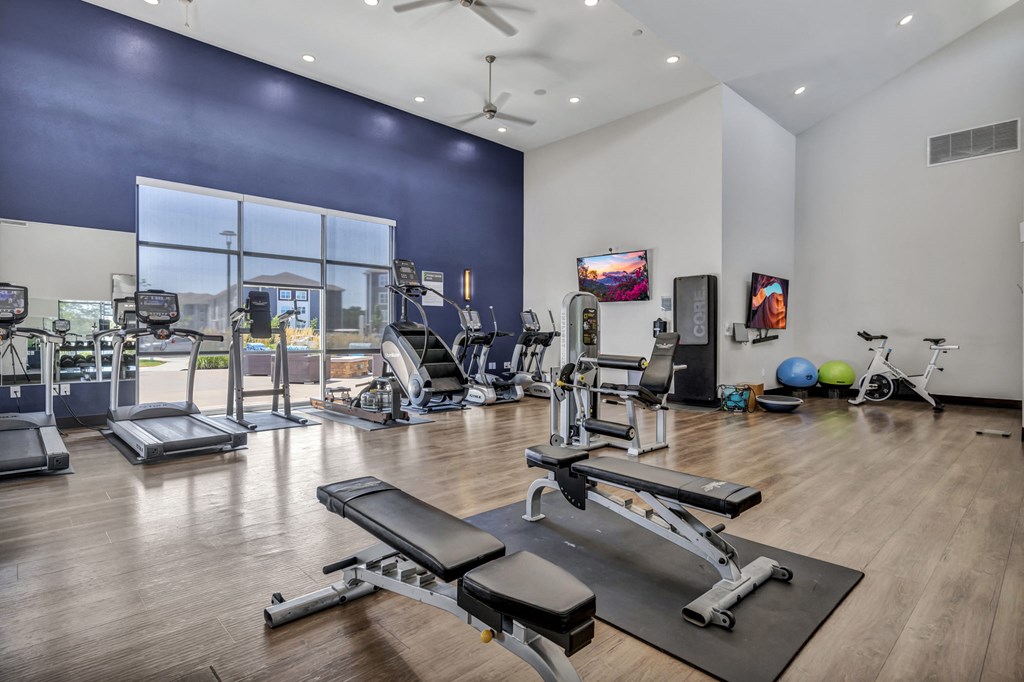 a gym with treadmills and other exercise equipment and a large window