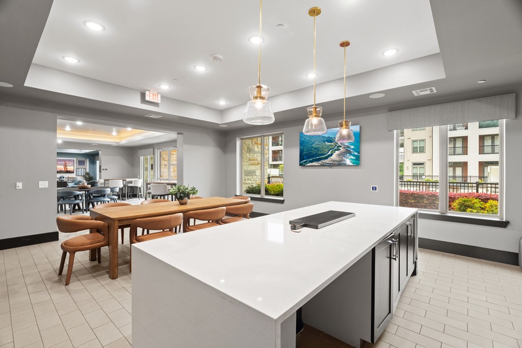 A modern kitchen with a large island and pendant lights.