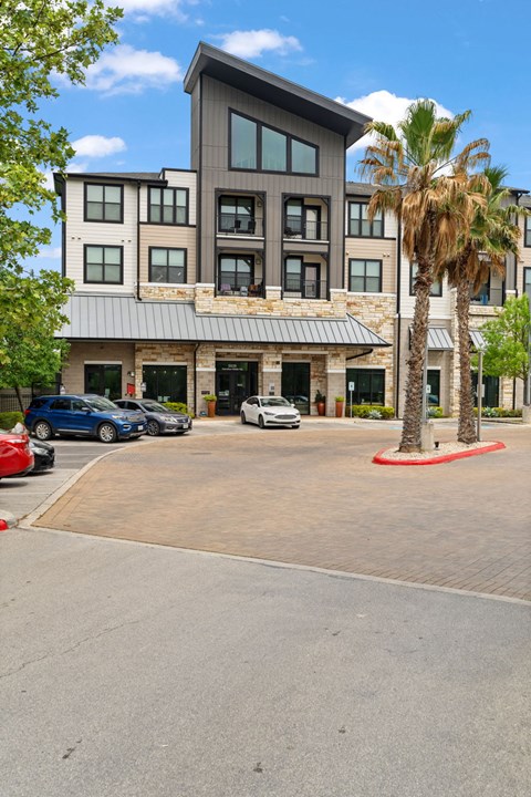 A modern building with a parking lot in front.