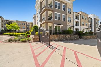 A gated parking lot in front of apartment buildings.