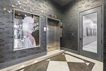 the lobby of a building with a poster on the wall and two doors