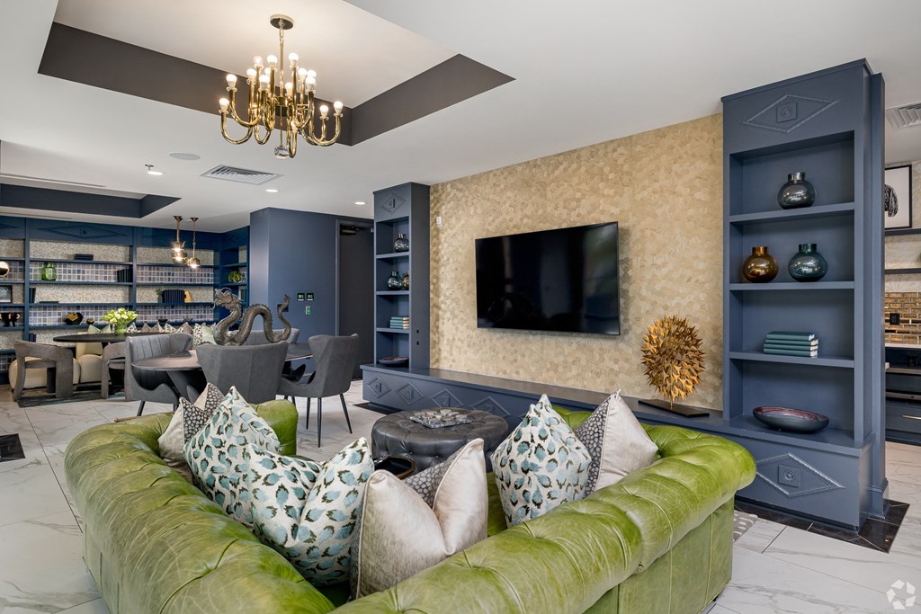 a living room with a green couch and a television
