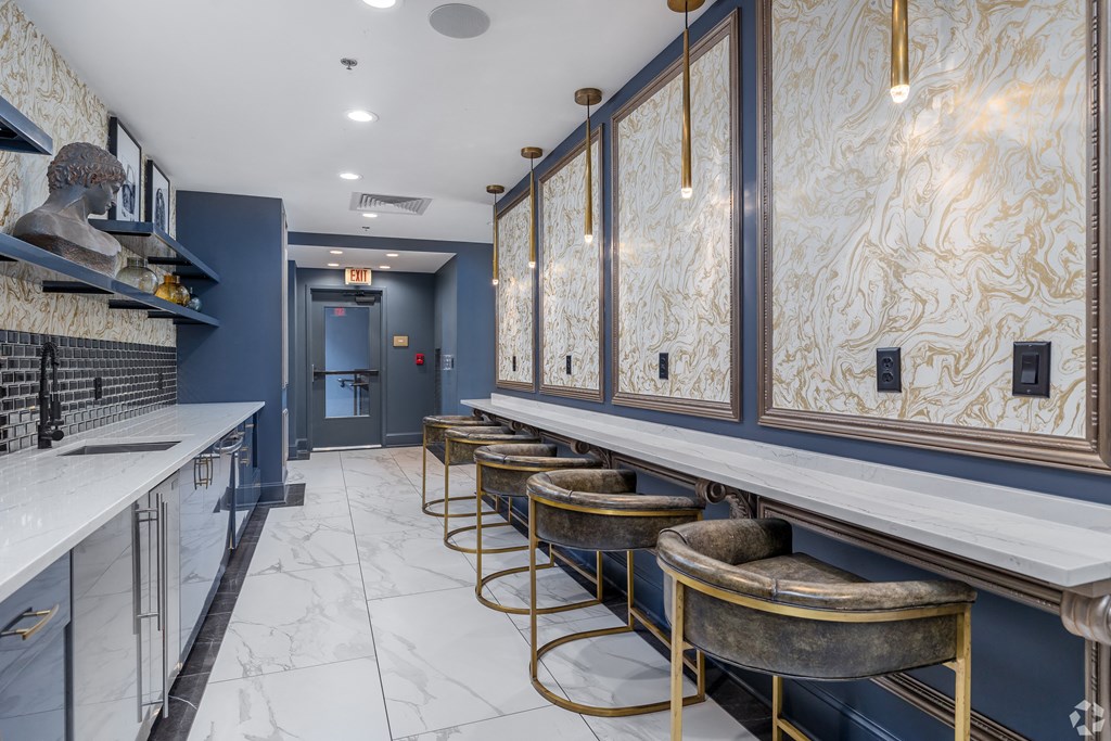a long bar with stools in a room with blue walls and marble floors