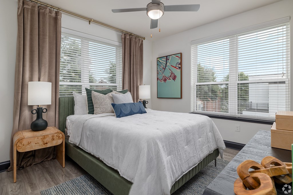 a bedroom with a large bed and two windows