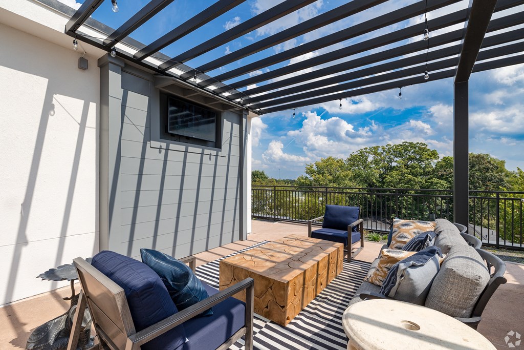 a patio with a pergola and furniture on it