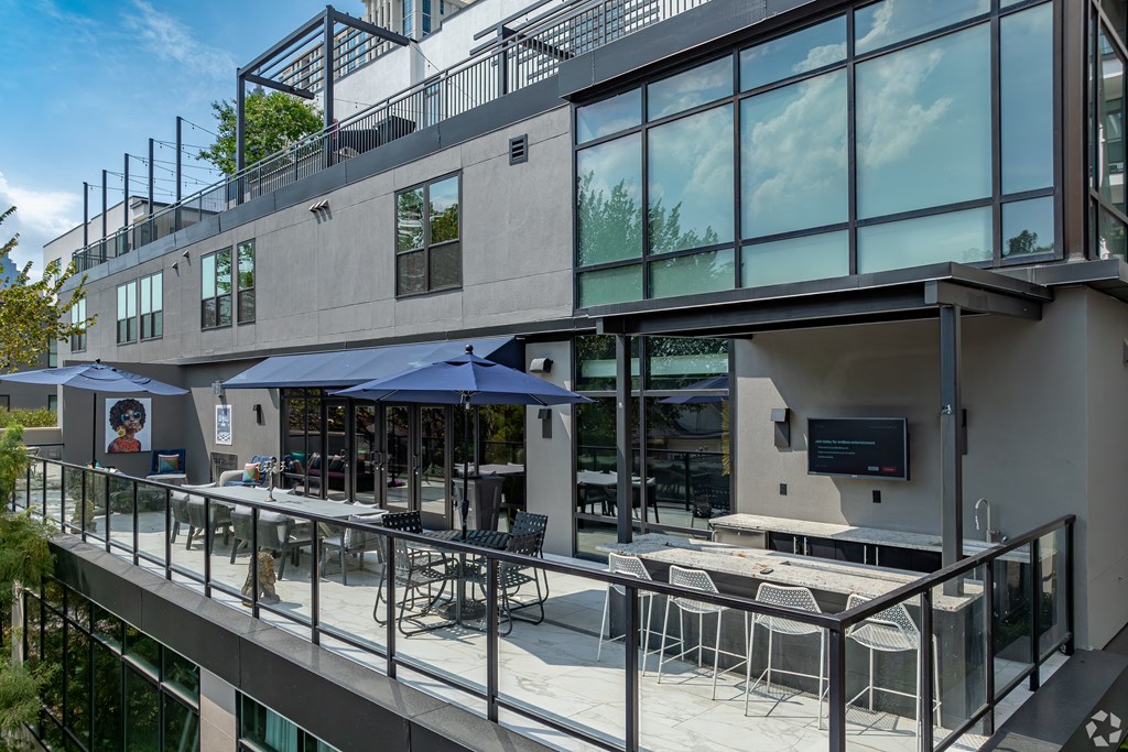 an exterior view of a building with tables and umbrellas