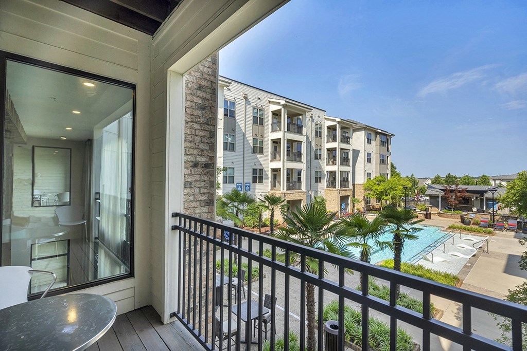 a balcony with a view of an apartment building and a pool