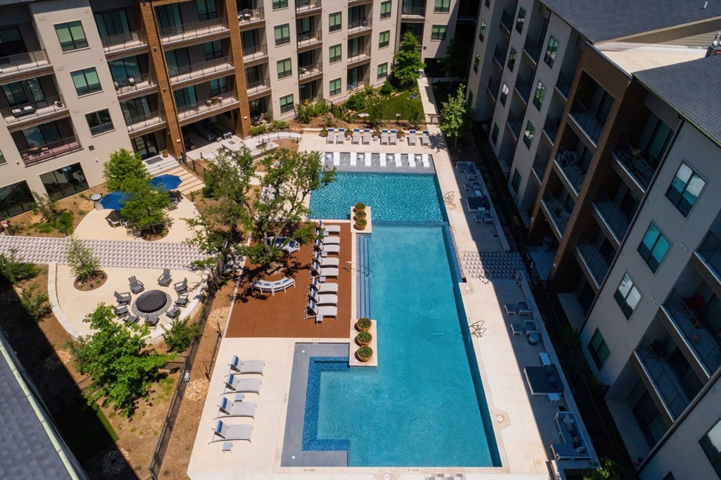an overhead view of a swimming pool in front of an apartment building