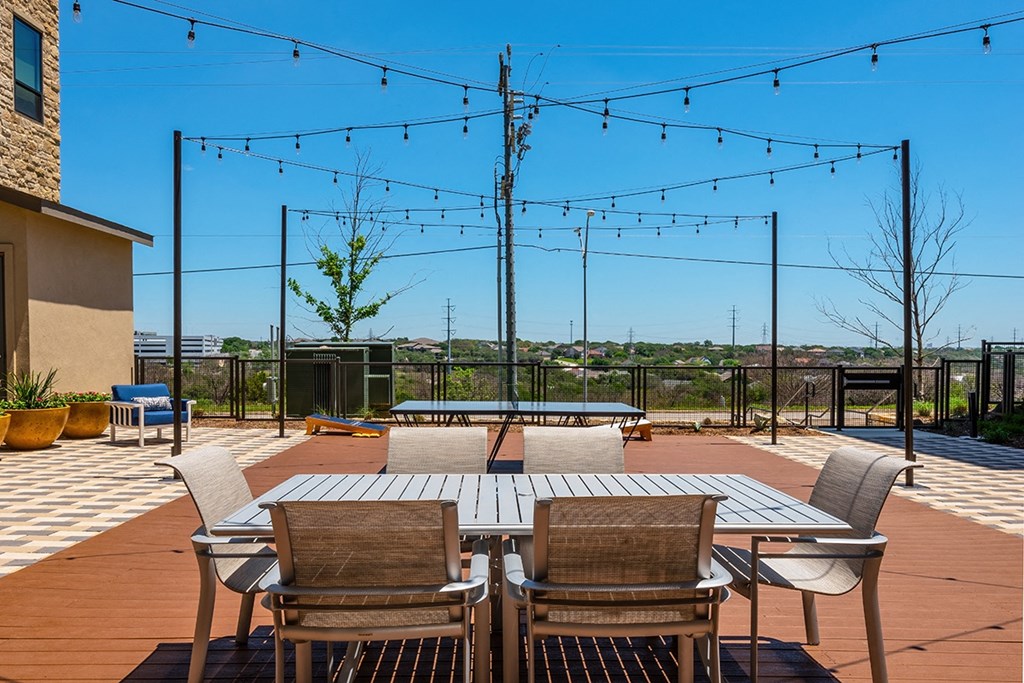 a patio with a table and chairs on a roof