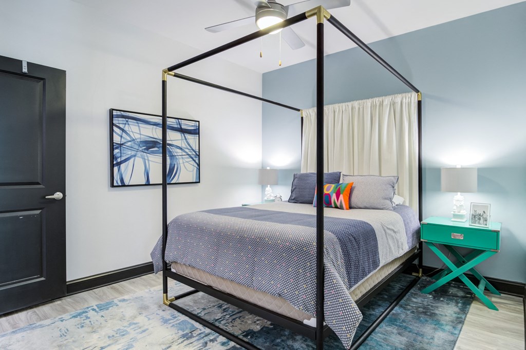 a bedroom with a canopy bed and a green nightstand