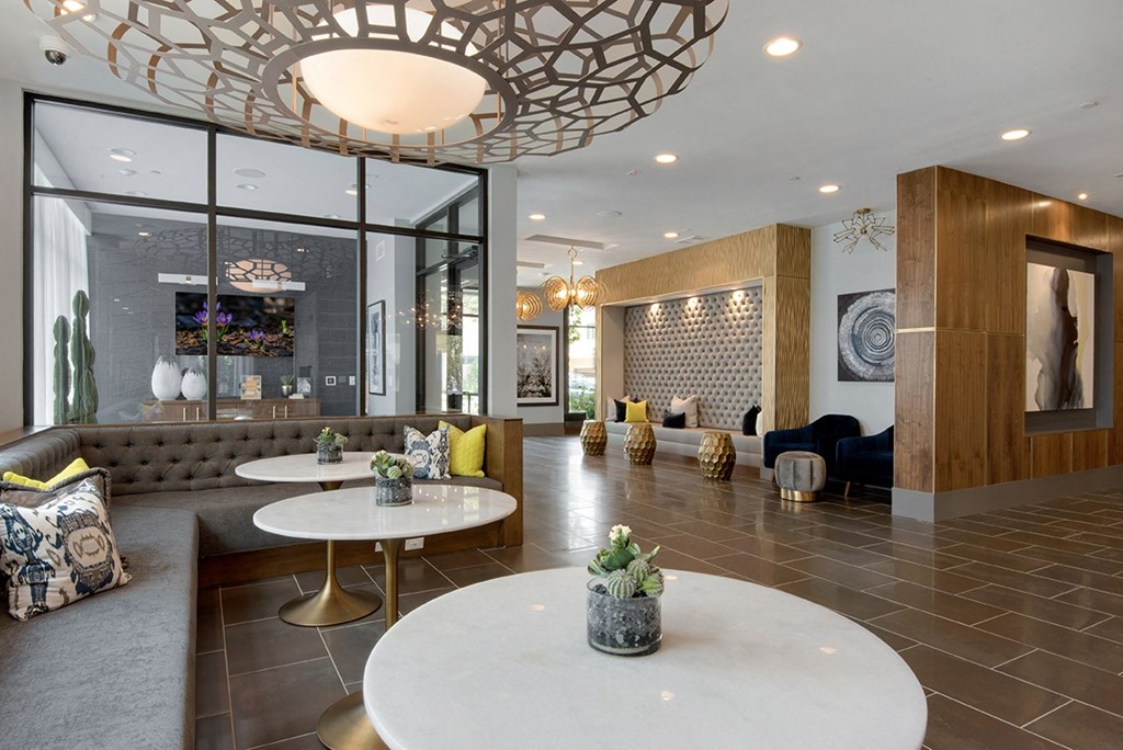 a lobby with tables and chairs and a large chandelier