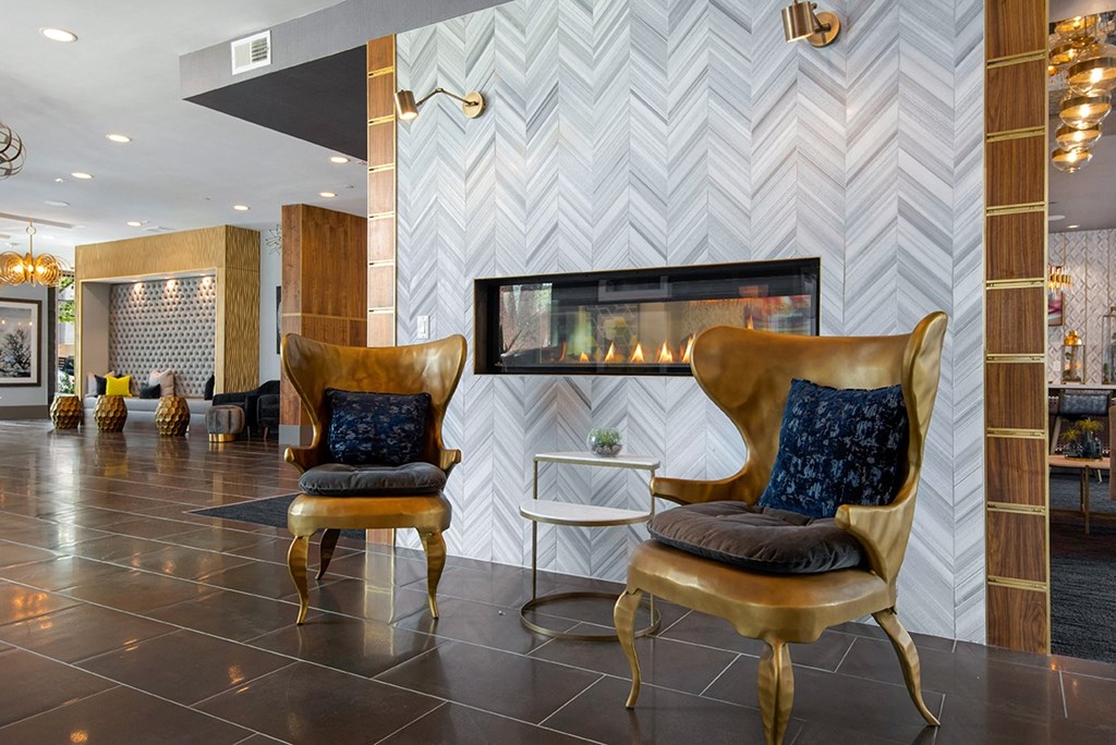 two chairs in front of a fireplace in a lobby