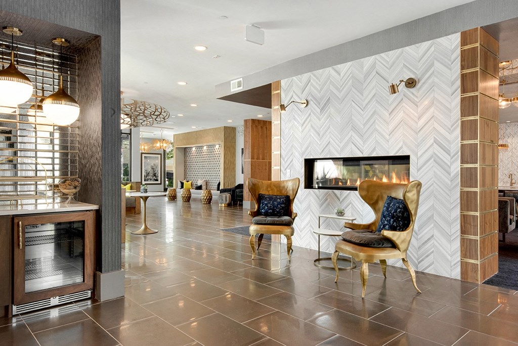 the lobby of a hotel with chairs and a fireplace