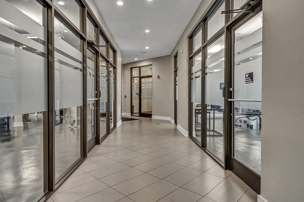 a hallway with glass doors and tables in a building
