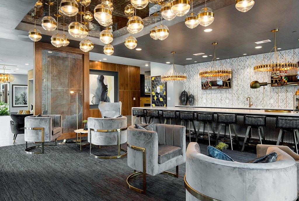 a lounge area with chairs and a bar and lights