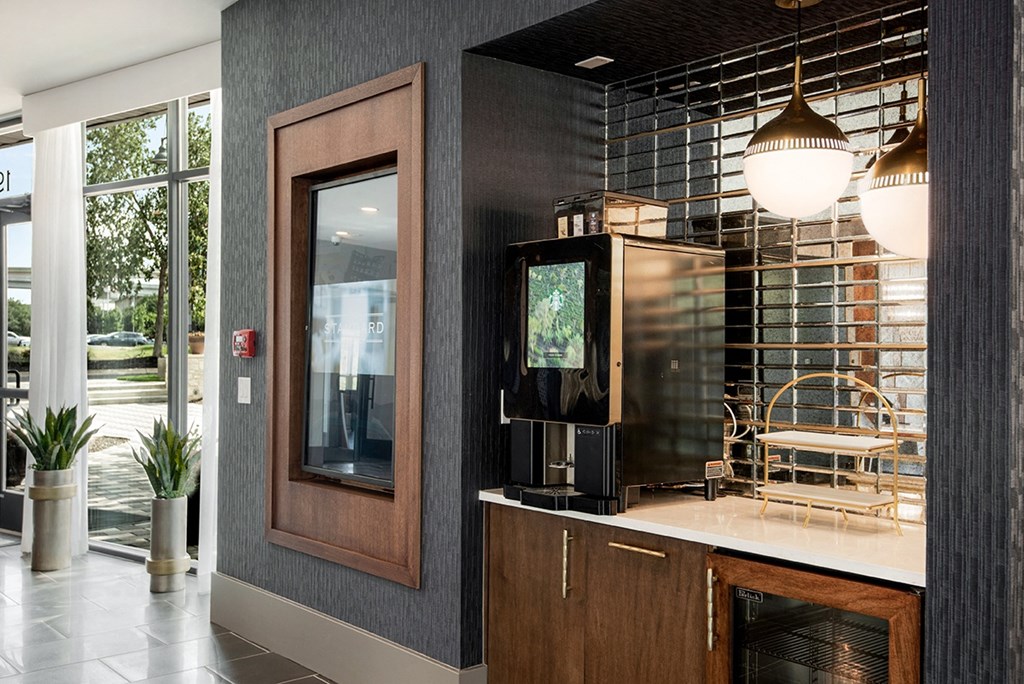 a lobby with a coffee machine and a table with a chair