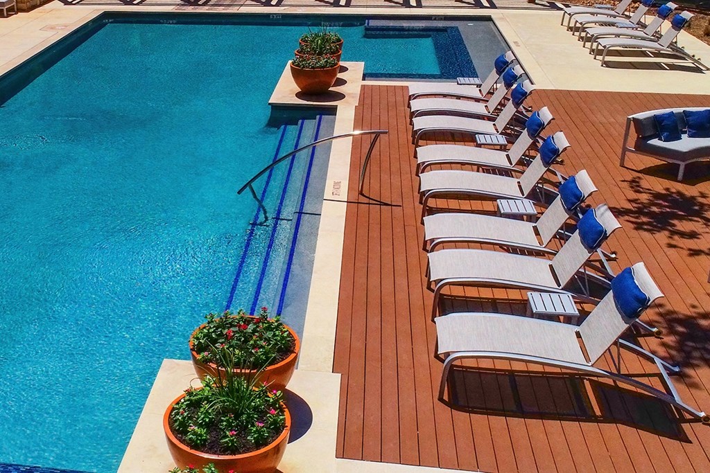 a row of lounge chairs next to a pool