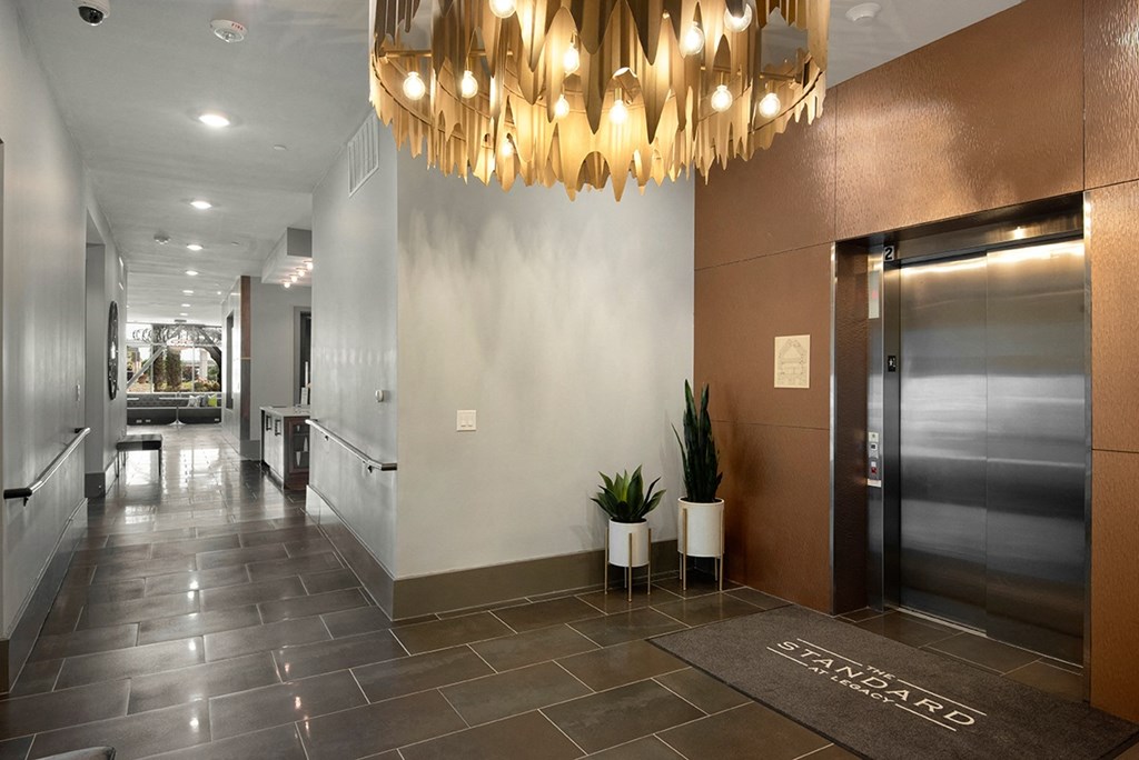 a lobby with a large elevator and a chandelier