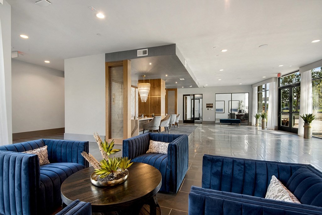 a large living room with blue couches and a table