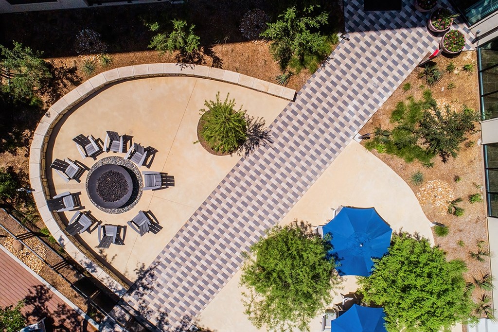 an overhead view of a courtyard with tables and umbrellas
