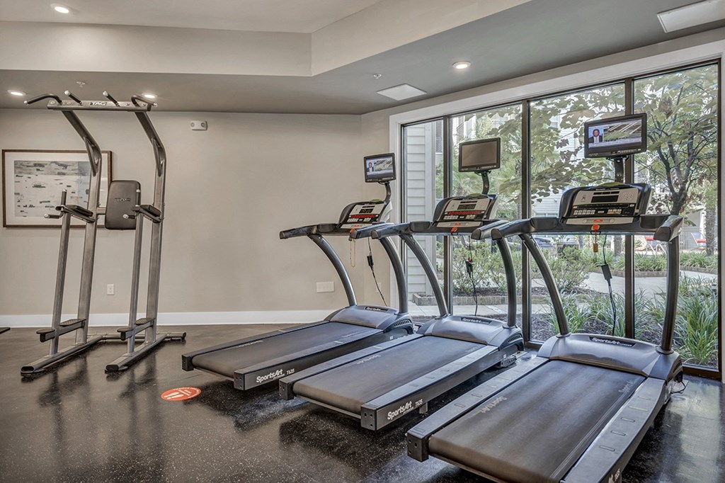 the fitness center has treadmills and a large window