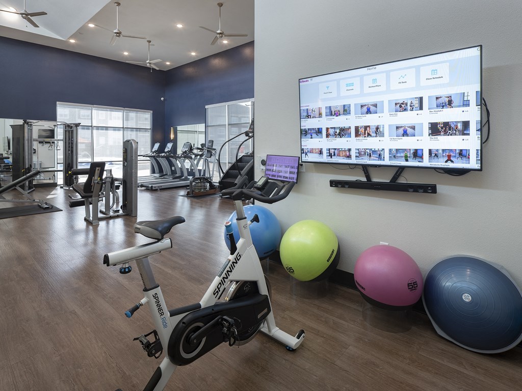 a gym with exercise equipment and a tv on the wall