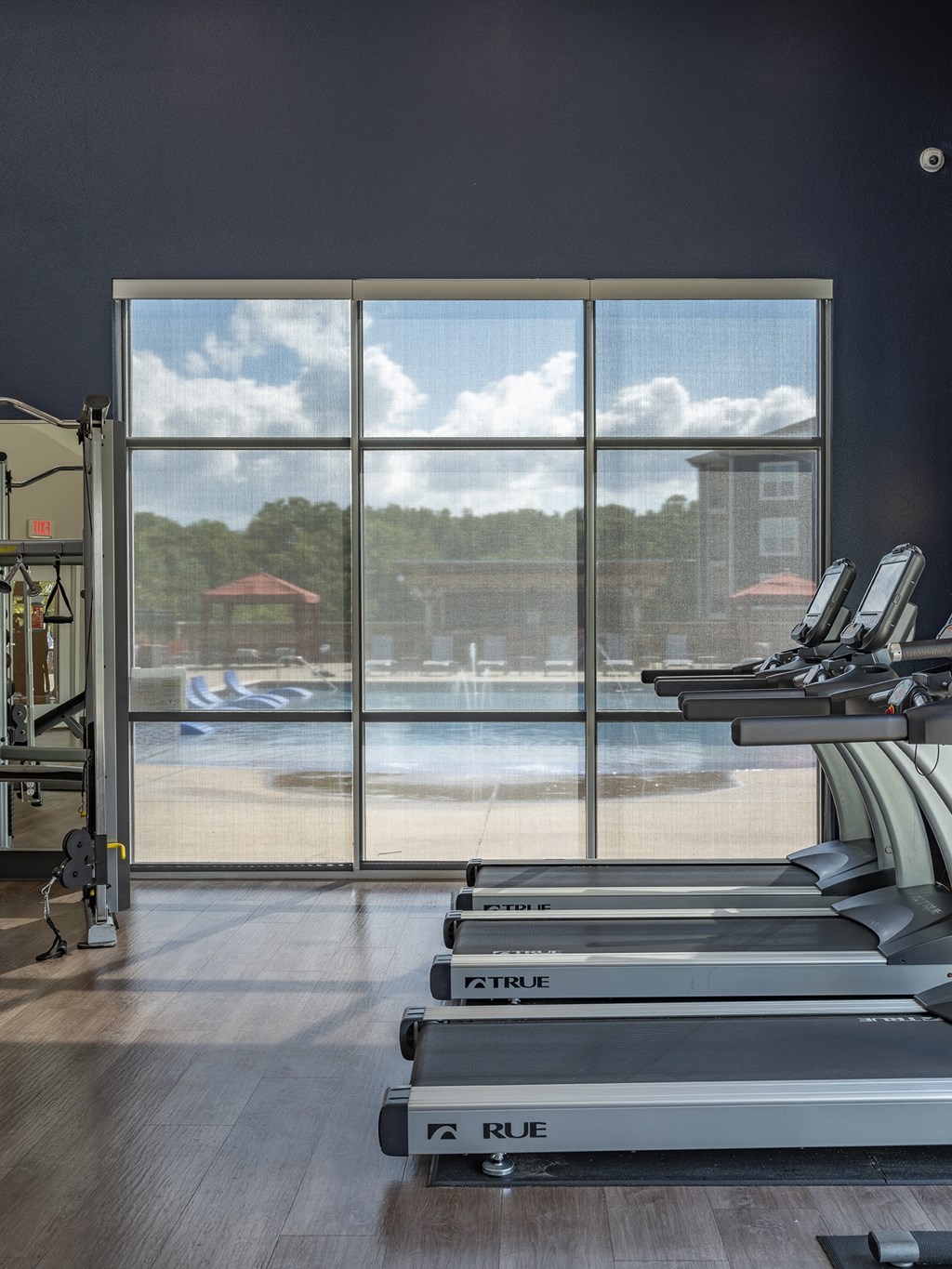 a gym with cardio machines and a view of a body of water
