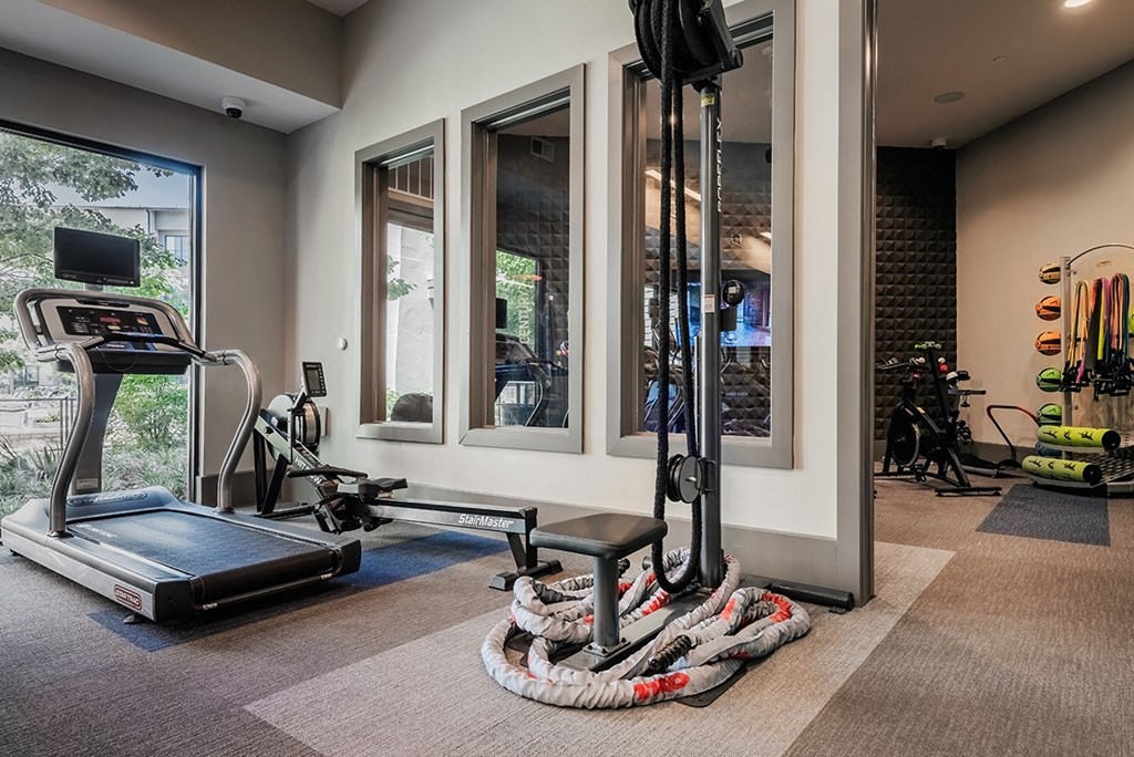 a home gym with exercise equipment and windows