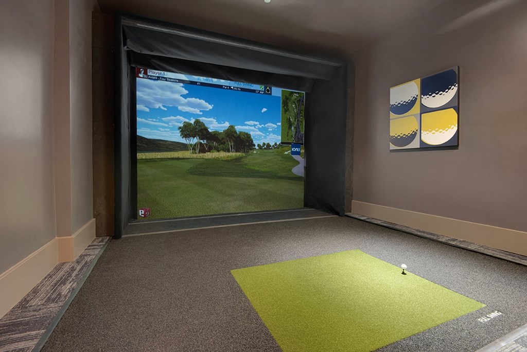 a golf simulator with a view of the golf course in a room with a door