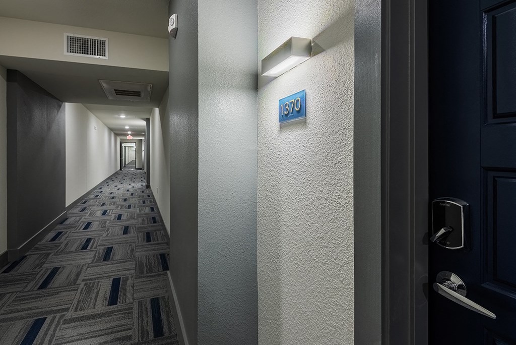 a hallway with a door and a sign on the wall