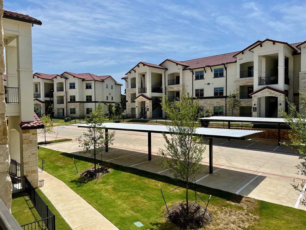 an exterior view of an apartment complex with a tennis court