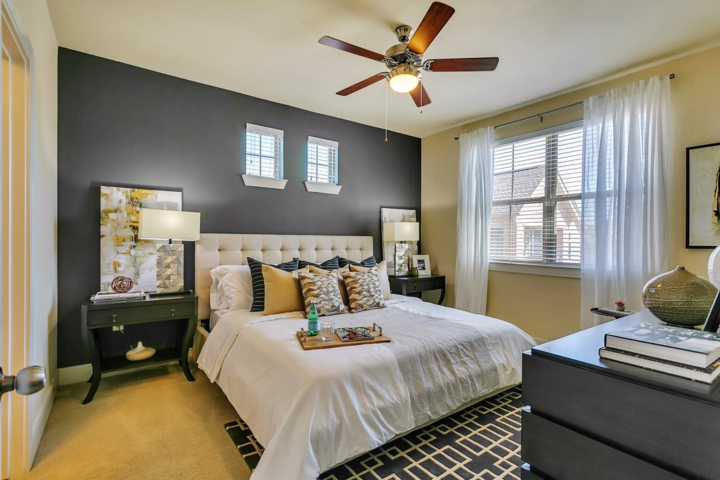 a bedroom with a large bed and a ceiling fan
