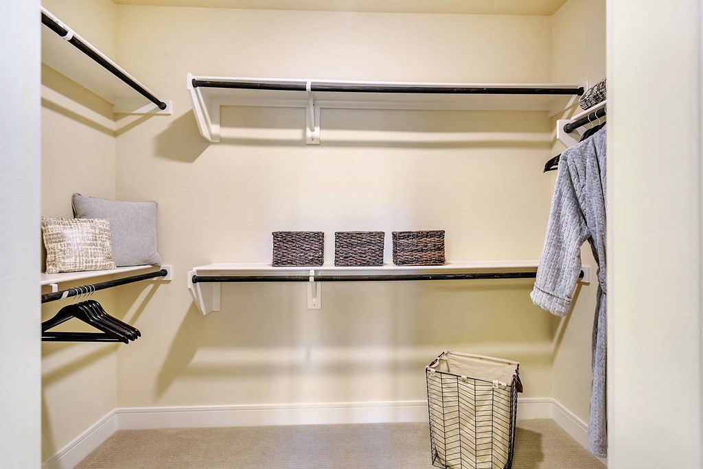 a walk in closet with a shelf and baskets in it