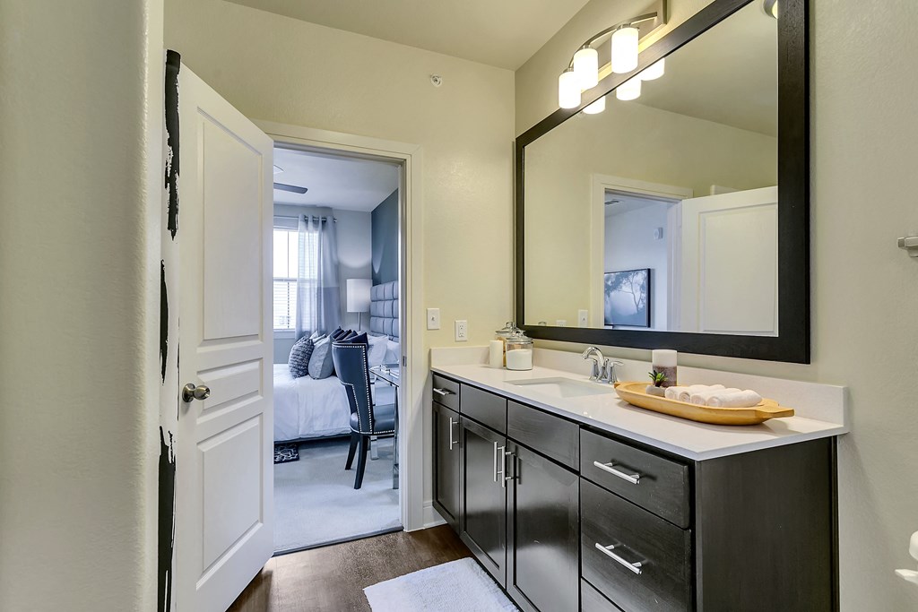 an open bathroom with a large mirror and a sink