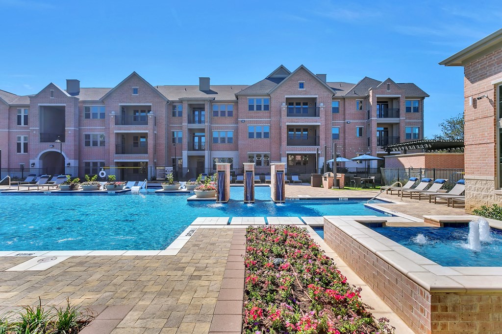 an outdoor swimming pool with a building in the background